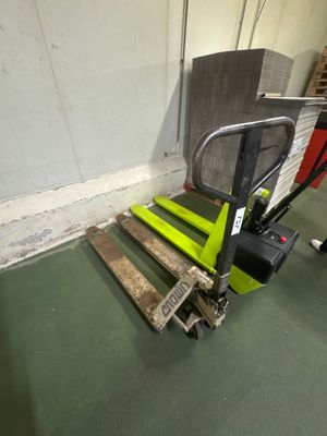 un chariot élévateur avec une palette fixée dessus dans un entrepôt