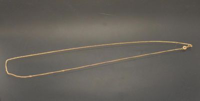a close up of a gold necklace on a black surface
