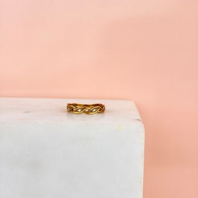 une bague en or posée sur un bloc de marbre blanc