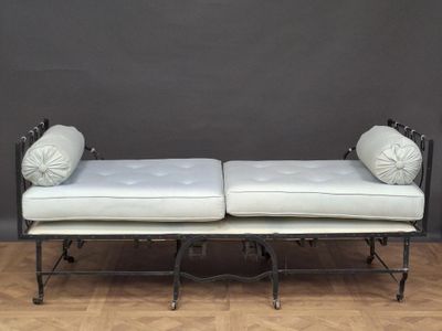 a white day bed with two pillows on top of it