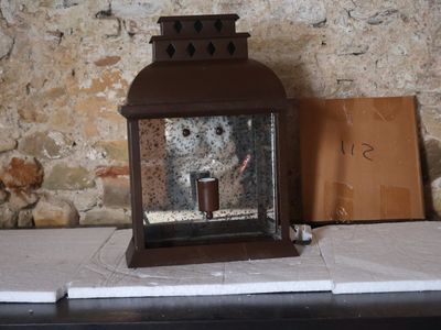 une bougie posée sur une table près d'un mur de briques