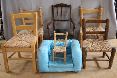 four chairs and a dog bed in front of a white curtain