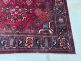 a large red rug on the floor with a cat on it