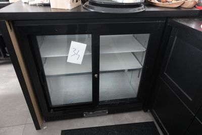 un réfrigérateur avec une porte vitrée au milieu d'une cuisine