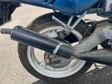 un gros plan d'une moto bleue avec un pot d'échappement noir