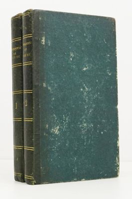 two green books sitting on top of each other on a white surface