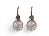 une image d'une paire de boucles d'oreilles en diamant sur fond blanc