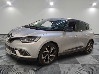 Une voiture argentée est garée sur un sol à damier dans une pièce