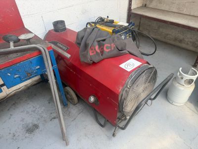 un radiateur rouge posé par terre à côté d'une machine bleue