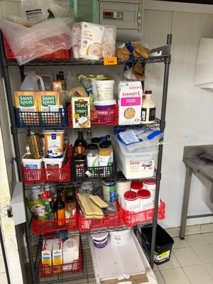 a metal shelving with many items on it in a kitchen