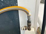 a hose attached to the side of a wall next to a fire hydrant