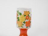 a small glass cup with a flower design on it