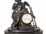 a statue of a boy with a clock on a table