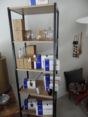 une étagère sur laquelle sont posées des boîtes et des verres, dans un salon
