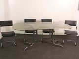 a glass table with chairs around it in a room