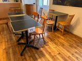 tables and chairs in a room with a painting on the wall