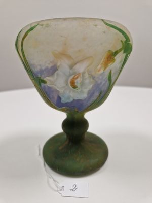 a glass vase with a flower on it on a table