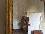 a large gold mirror in the corner of a room