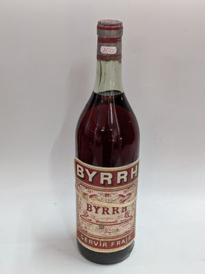 an old bottle of wine sitting on top of a white table