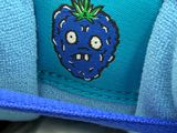 a person holding a blue shoe with a blue strawberry on it