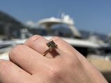 a person holding a ring in their hand near a boat