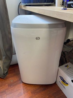 a white trash can sitting on the floor next to a desk