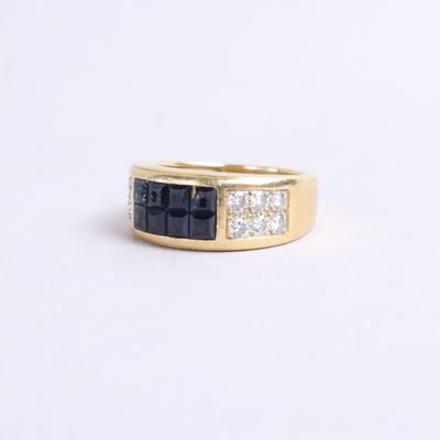 a close up of a yellow gold ring with black and white diamonds