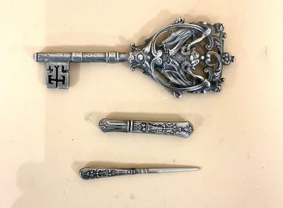 une clé en argent et quelques autres objets posés sur une table