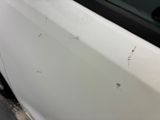 a close up of a white car with scratches on the door