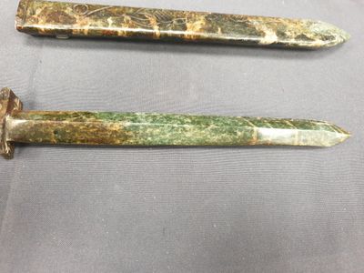 deux couteaux verts et dorés posés sur une table