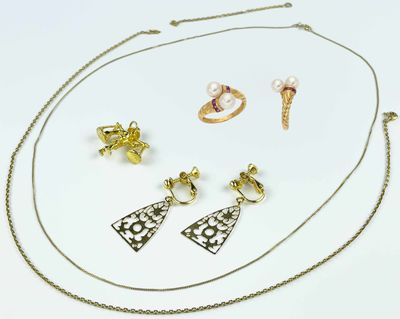 a close up of a necklace, earrings, and ring on a white surface