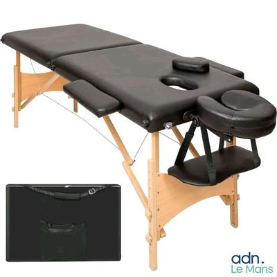 a close up of a massage table with a black cover
