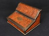 a small wooden writing desk with a black background