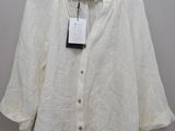 a white shirt hanging on a hanger on a wall