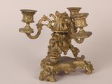 an antique brass candelab with two candles on a stand