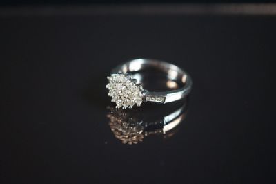 gros plan d'une bague en diamant sur une surface noire
