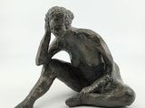 statue of a man sitting on the ground with his hand on his head