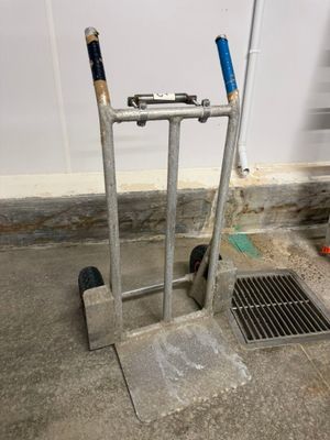 a hand truck with two baseball bats on top of it