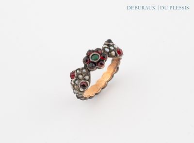 un gros plan d'une bague sertie de pierres rouges et vertes
