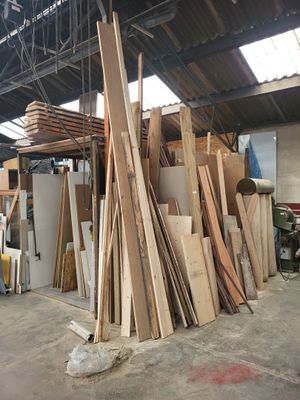 plusieurs pièces de bois sont empilées dans un entrepôt