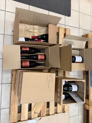 Plusieurs caisses de vin sont empilées les unes sur les autres dans une pièce