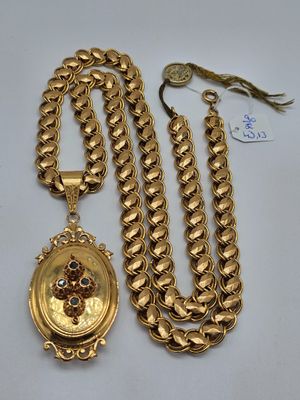 un gros plan sur un collier en or et une chaîne ornée d'un médaillon
