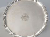 an antique silver plate on a table with a white background