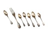 six silver spoons and a fork are lined up on a white surface