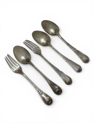 five silver spoons and a fork on a white surface