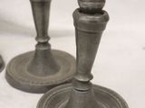 two metal candlesticks sitting on a white table