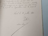 an open book with a handwritten letter on it sitting on top of a table
