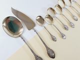 a lot of spoons and spoon knives on the table