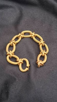 gold plated bracelet with a link and clasp on a black background