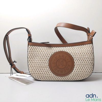 un sac à main posé sur une table, avec une étiquette dessus